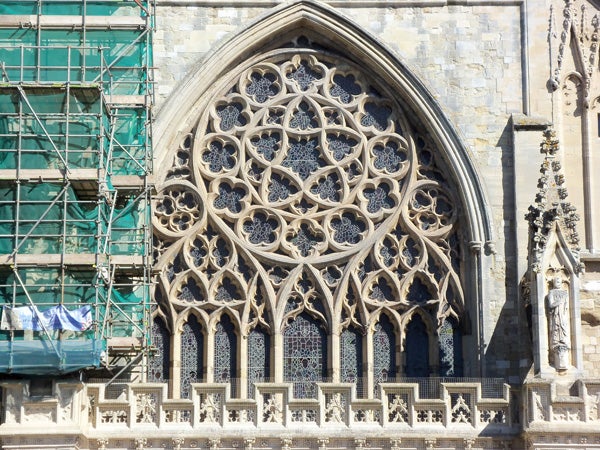 Intricate Gothic window architecture with scaffolding on the side.