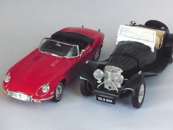 Model cars, red Jaguar E-Type and black vintage convertible.