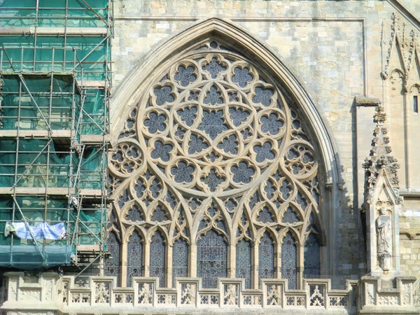 Intricate gothic window architecture with scaffolding on one side