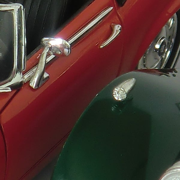 Close-up photo of red and green objects with a reflective surface.