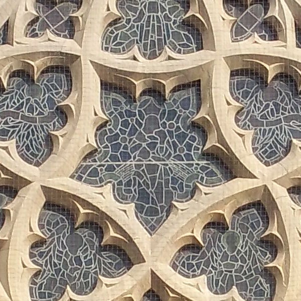 Intricate stone lattice work on a building facade.