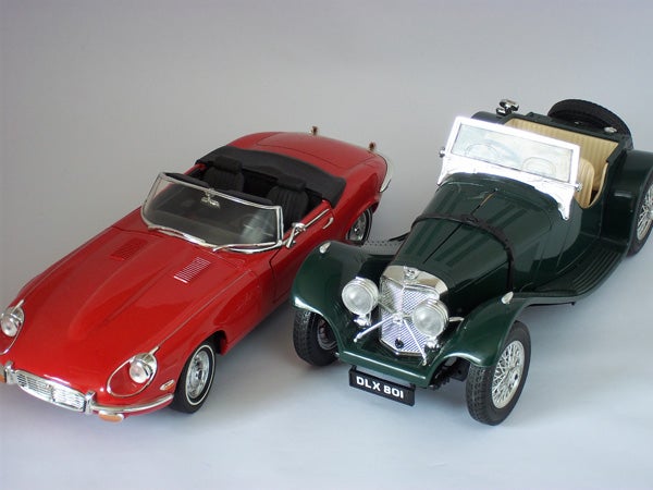 Model cars: Red Jaguar E-Type and Green Vintage Convertible.