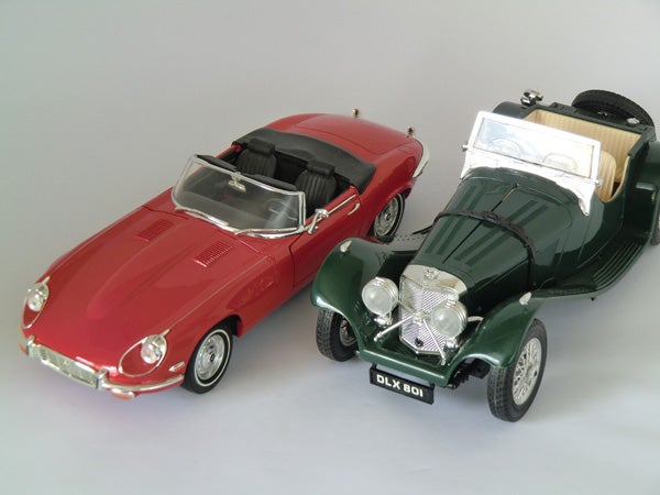 Two model cars displayed on a gray surface.