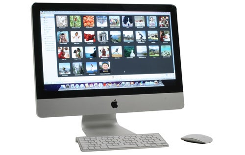 Apple iMac 21.5-inch 2010 model with photo album on screen.