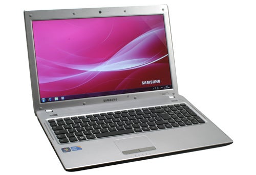 Samsung Q530 laptop with screen displaying logo on desk.