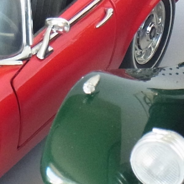 Detail of red and green vintage cars with chrome detailing.