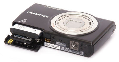 Olympus FE-5050 camera with open memory card and battery slots.
