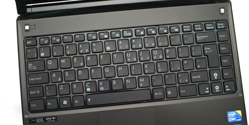 Close-up of Asus U35Jc laptop keyboard and stickers.