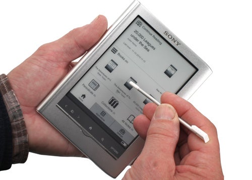 Hand holding Sony Pocket Reader PRS-350 with stylus.