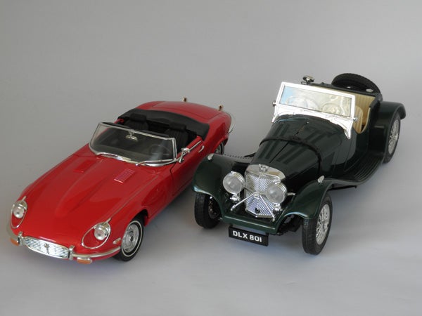 Two model cars on a gray background