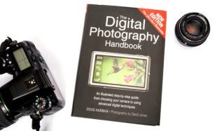 Digital Photography Handbook beside a camera and lens.