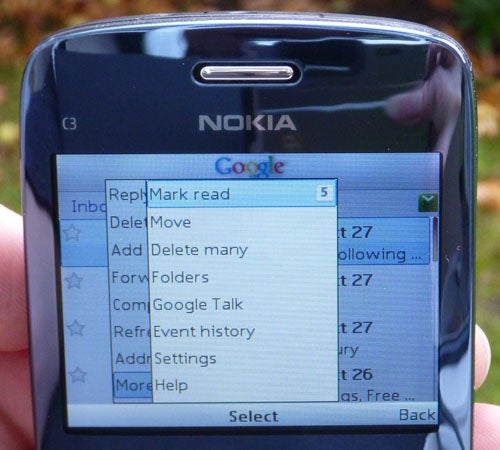 Hand holding Nokia C3 showing Google search and menu options.