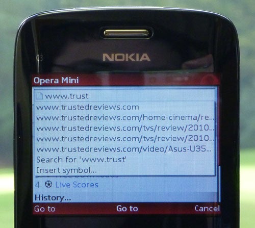 Nokia C3 phone displaying Opera Mini browser with Trusted Reviews website.