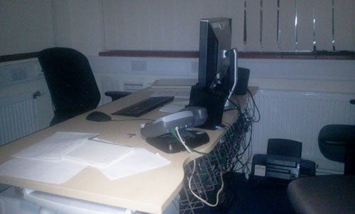 Office desk with computer setup, papers, and telephone