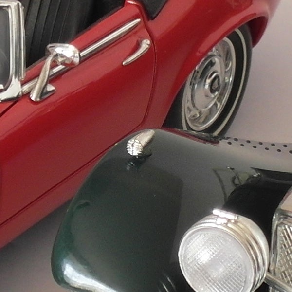 Close-up of a vintage toy car reflected in a camera lens