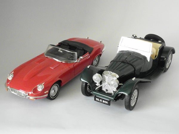 Two model cars displayed on a gray surface.