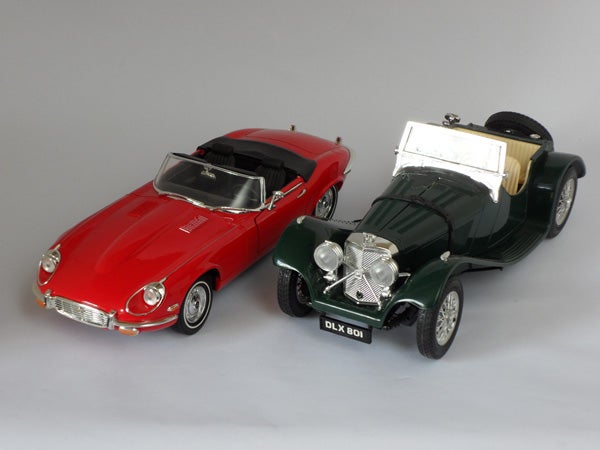 Red Jaguar E-Type and green classic car toy models on display
