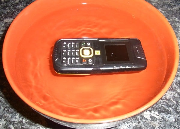 JCB Tradesman Toughphone submerged in water for durability test.