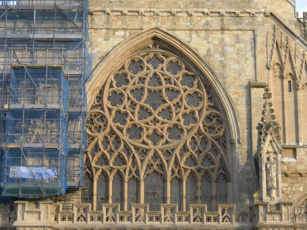 Ornate gothic window on a cathedral with scaffolding on the side