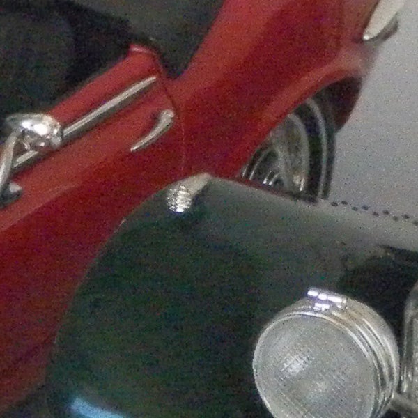 photo of a red car and motorcycle headlight.