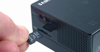 Samsung H03 projector with microSD card being inserted