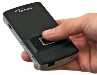 Hand holding an Optoma PK201 pico projector.