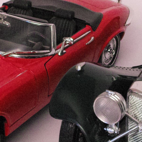 Close-up of red and black model cars with a grainy texture.