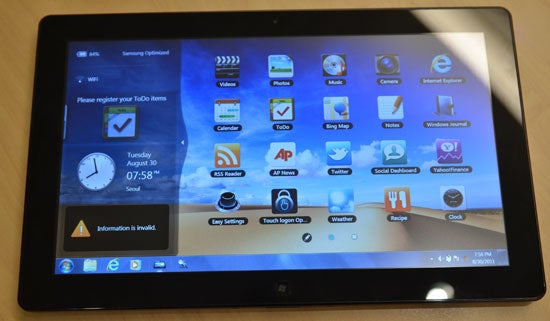 Samsung Omnia 7 GT-i8700 smartphone displaying colorful icons on screen
