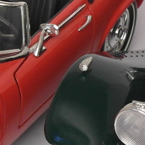 Close-up of a red toy car and camera lens.