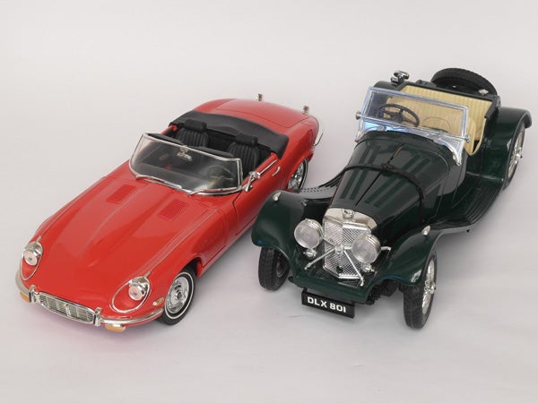 Two vintage model cars, red and green, on white background.