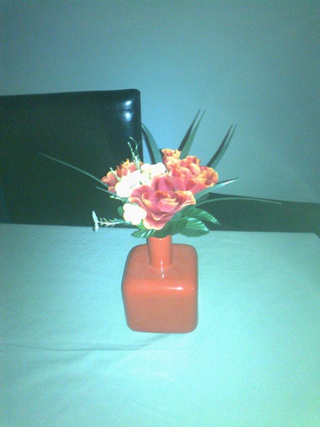 Flower arrangement in a red vase on a table.