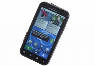Motorola Defy smartphone with screen turned on displaying apps.
