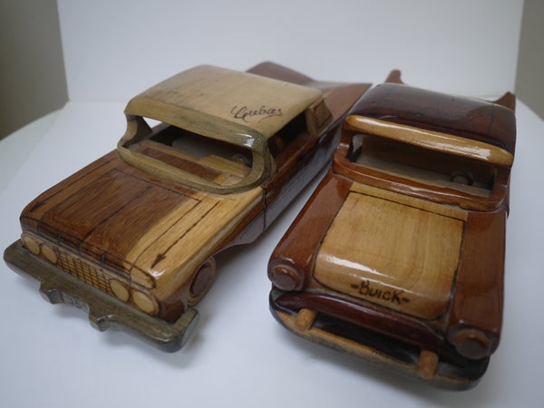 Handcrafted wooden toy cars on a white background.