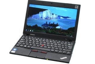 Lenovo ThinkPad X100e laptop with open screen displaying wallpaper.