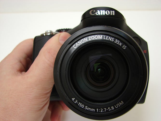 Close-up of Canon PowerShot SX30 IS camera held in hand.