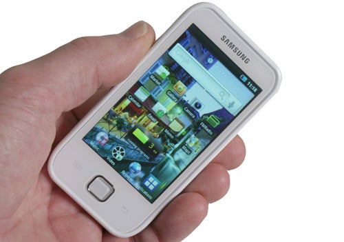 Hand holding a Samsung Galaxy Player 50 displaying home screen.