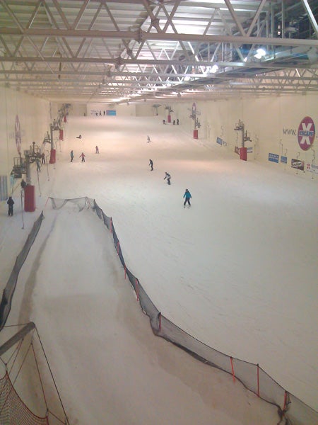 Indoor skiing facility with skiers on the slope.