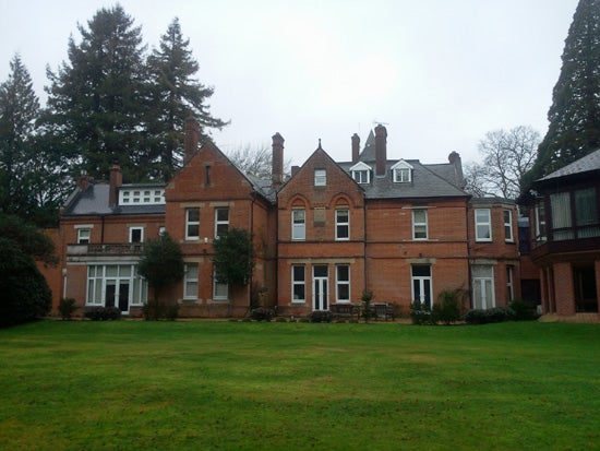 Victorian-style brick mansion with large lawn.