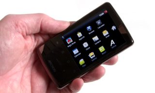 Hand holding an Archos 28 Internet Tablet displaying apps.