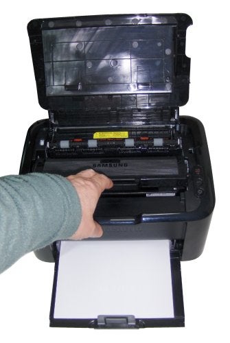 Hand placing paper into Samsung ML-1865W laser printer.