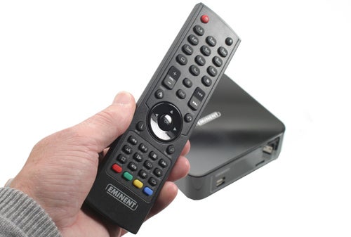 Hand holding Eminent hdMEDIA RT EM7080 media player remote.