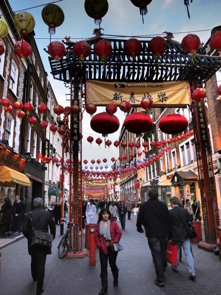 Photo of a bustling street decorated with red lanterns.