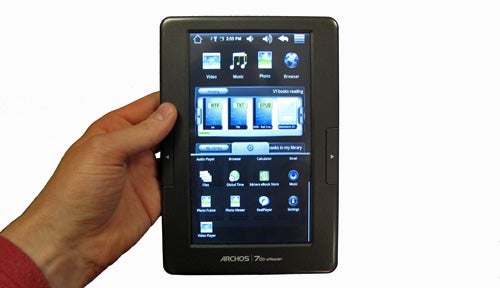 Hand holding Archos 70b eReader displaying home screen.