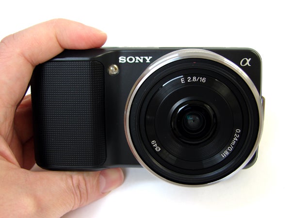 Hand holding a Sony Alpha NEX-3 camera.