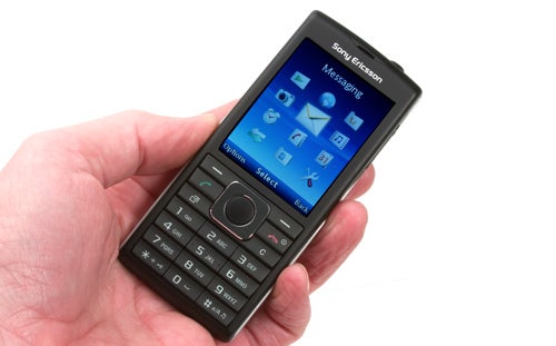Hand holding a Sony Ericsson Cedar mobile phone.