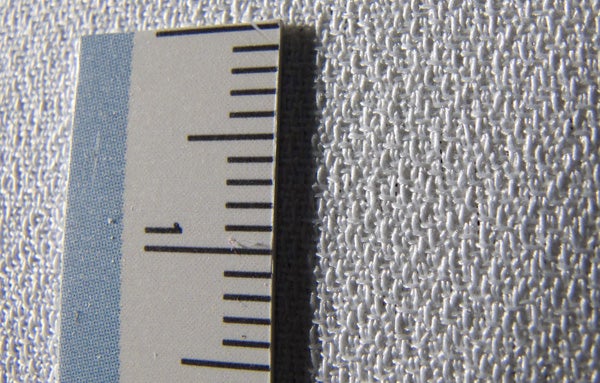 Close-up of Screen Excellence RM2-T projector screen texture with scale.