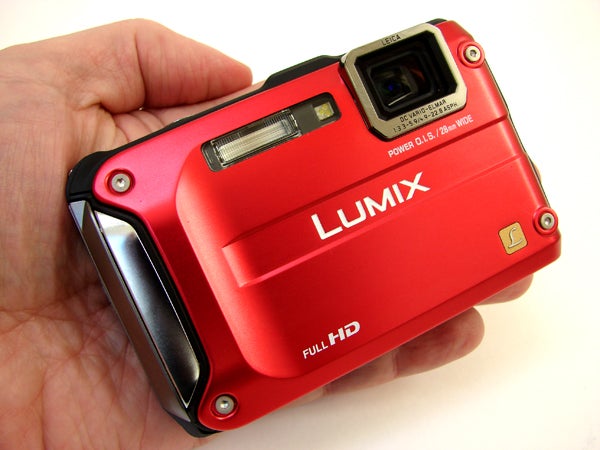 Hand holding red Panasonic Lumix DMC-FT3 camera.