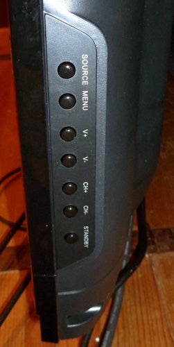 Close-up of Technika LCD 32-270 TV side control buttons.
