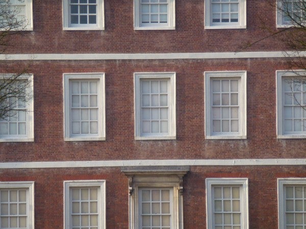 Brick building facade with multiple windows, sharp detail.
