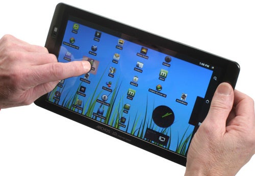 Hand touching Archos 101 Internet Tablet on home screen.